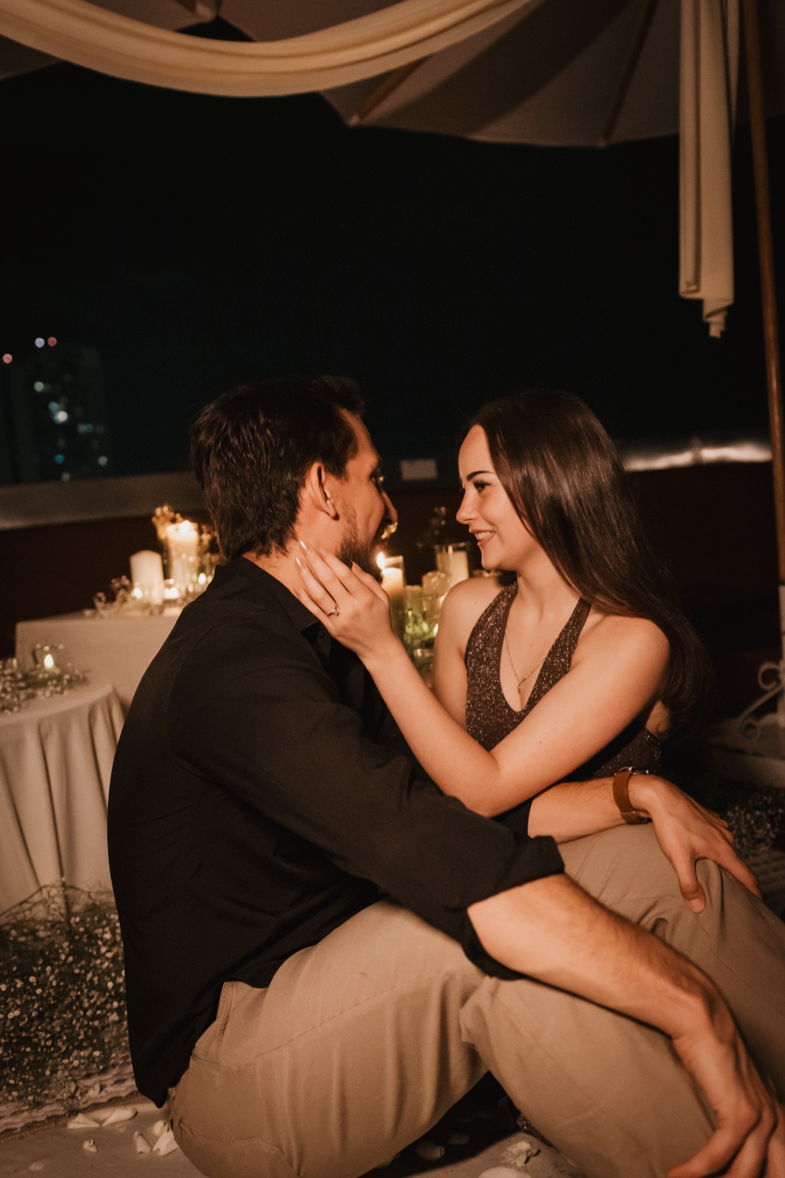 Pareja abrazada y mirándose durante una celebración nocturna